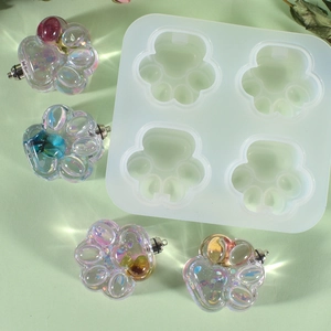 Macro view of 4-cavity cat paw silicone mold with iridescent resin charms and dried flowers