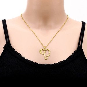 Detailed shot of a gold Venezuela map pendant necklace with heart on a model's neck