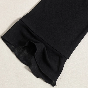 Détail des poignets à volants en maille noire avec texture de tricot fin respirant