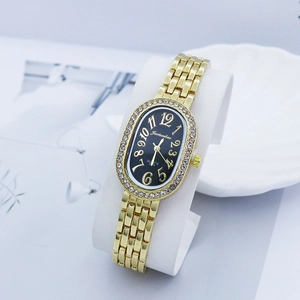 Detail of luxury gold women's watch with rhinestone bezel and oval black dial on display