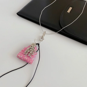 Vue détaillée d'un pendentif sac à main en strass rose sur une chaîne à perles argentée