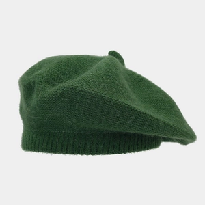 Detailed close-up of dark green knitted wool beret showing soft plush texture and ribbed edge