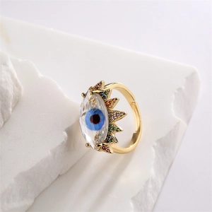 Macro shot of gold adjustable ring featuring evil eye design with colorful zircon stones