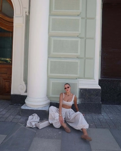 Detail of a minimalist cream two-piece set featuring a cropped tank top and lantern pants