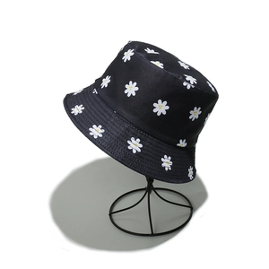 Close-up of small white daisy floral print on black cotton canvas sun bucket hat