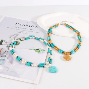 Bohemian layered turquoise bead necklace set with heart pendants on a white background
