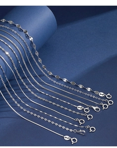 Detailed macro shot of various 925 sterling silver chain styles on a navy textured background