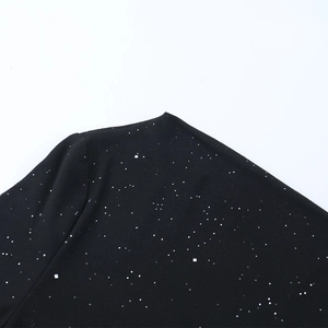 Détail du tissu d'une robe de soirée noire avec paillettes argentées scintillantes effet étoilé