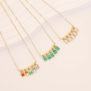 Detailed view of geometric square glass pendants in white, green, and multicolor on gold chains