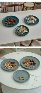 Close-up of wavy metal snack trays with natural texture holding mixed nuts and dried fruits