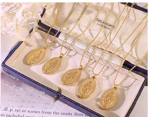 Detailed macro view of 18K gold plated portrait oval pendant necklace on blue jewelry box