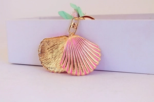 Detail of pink gradient enamel seashell keychain with golden lobster clasp and ring