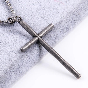 Macro view of vintage grey stainless steel cross pendant and round box chain necklace
