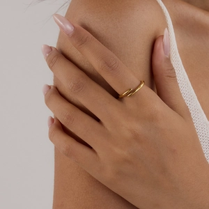 Close-up of golden 18K stainless steel wrap ring worn by a model for a minimalist style
