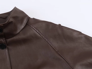 Close-up of deep brown faux leather jacket collar with button and stitching details