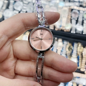 Détail de la montre chaîne en métal argenté JW avec cadran or rose au marché