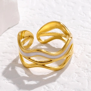 Macro shot of wave-shaped gold stainless steel open ring with white enamel detail