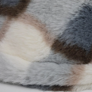 Detailed macro view of soft faux fur texture in white, grey, and coffee color patchwork
