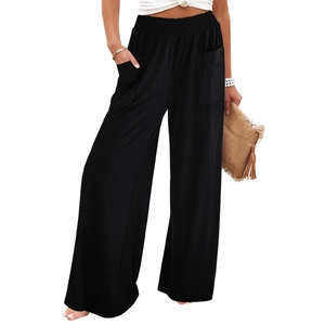 Detail of high-waist black wide-leg joggers featuring elastic waistband and side pockets