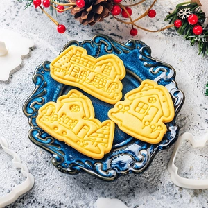 3-piece Christmas gingerbread house cookie mold set with plastic cutters on blue plate