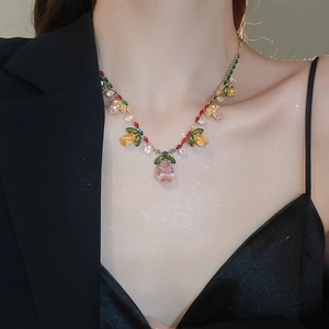 Close-up of zircon flower drop necklace with colorful pink and red crystal stones on model