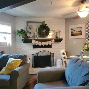 Close-up of bohemian cotton rope macrame wall hanging above a black wooden fireplace