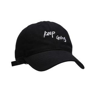 Black cotton baseball cap with white Keep Going embroidery in a minimalist style