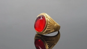 Detailed side view of vintage gold ring featuring a large oval red gemstone inlay