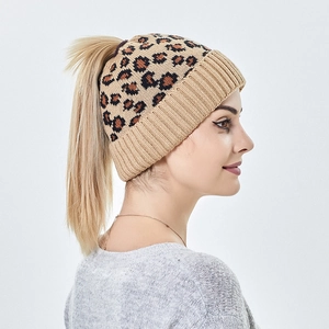 Détail latéral d'un bonnet en maille léopard avec une ouverture pratique pour queue de cheval