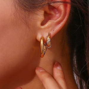 Polished 18K gold-plated heart earrings and twisted zircon hoops on a female model