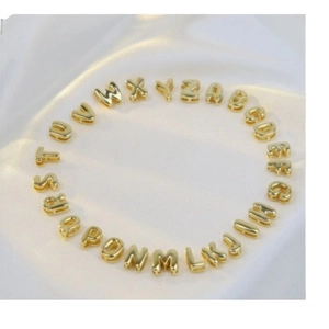 Golden balloon style A-Z initial letter pendants displayed on white silk background