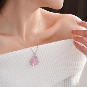 Close-up of pink translucent Buddha pendant necklace with sparkling zircon flower frame