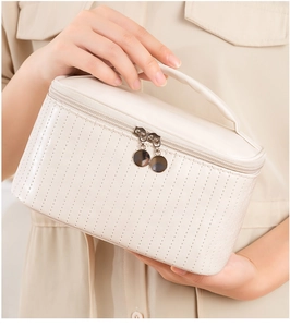 Detailed view of a white PU leather makeup bag featuring a handle and double zippers