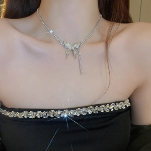 Macro detail of butterfly tassel necklace with sparkling rhinestones on model neck