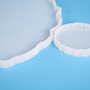 Close-up of two translucent wavy silicone molds for DIY resin coasters and trays