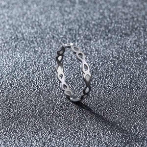 Detail of 304 stainless steel ring with hollow infinity pattern on textured surface
