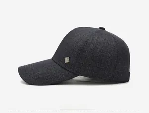 Detailed side view of a dark grey men's baseball cap with a square metal logo accent