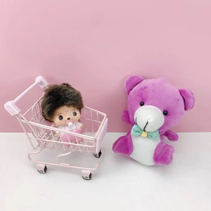 Detailed view of a mini pink iron wire storage basket holding a cute plush doll