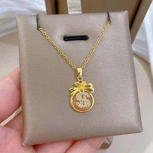 Macro shot of gold money bag pendant necklace featuring a crystal-set dollar sign detail