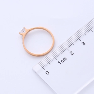 Size measurement of rose gold ring with zircon, showing 1.7cm inner diameter on scale