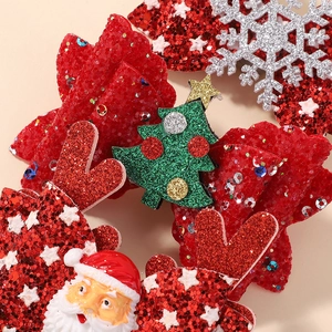 Macro detail of Christmas hair clips with glitter reindeer antlers and sequined Santa Claus
