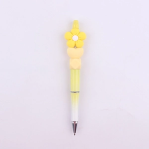 Detail of DIY beaded pen with yellow daisy flower silicone charms and gradient pen body