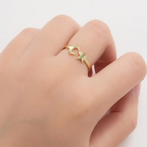 Minimalist gold star and moon open ring shown on hand in a stylish jewelry close-up