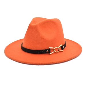 Dettaglio del cappello fedora arancione con fascia nera e fibbia a catena dorata
