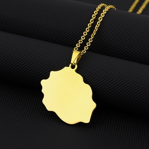 Polished gold Reunion Island map pendant necklace in stainless steel on black textured stand