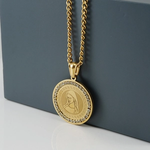Detail of 18K gold-plated necklace with Mary relief and crystal circle on gray background