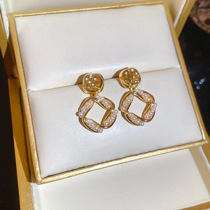 Close-up of 18K gold plated square drop earrings with pearls in a luxury jewelry box
