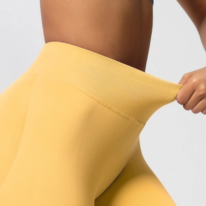Detail der gelben Yoga-Leggings mit dehnbarem Rippbündchen und hochelastischer Stoffstruktur