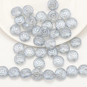 Macro detail of light blue spiral pattern glass beads for DIY jewelry making