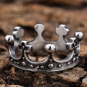 Retro stainless steel crown ring with cross motif for men on rustic wood background
